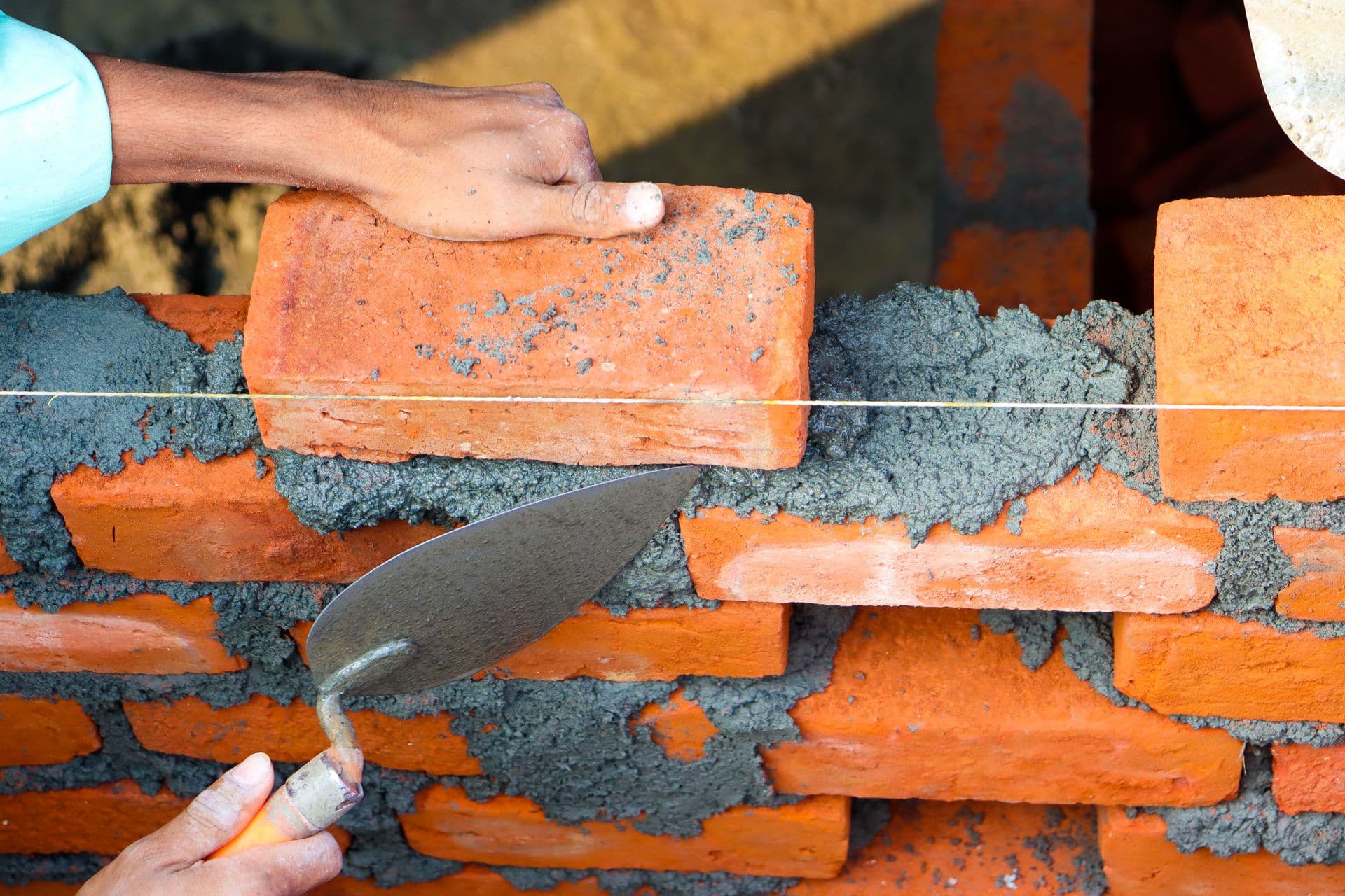 Mason laying brick with a trowel